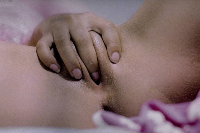 Leona lies down to tease her shaved pussy in bed photo 21